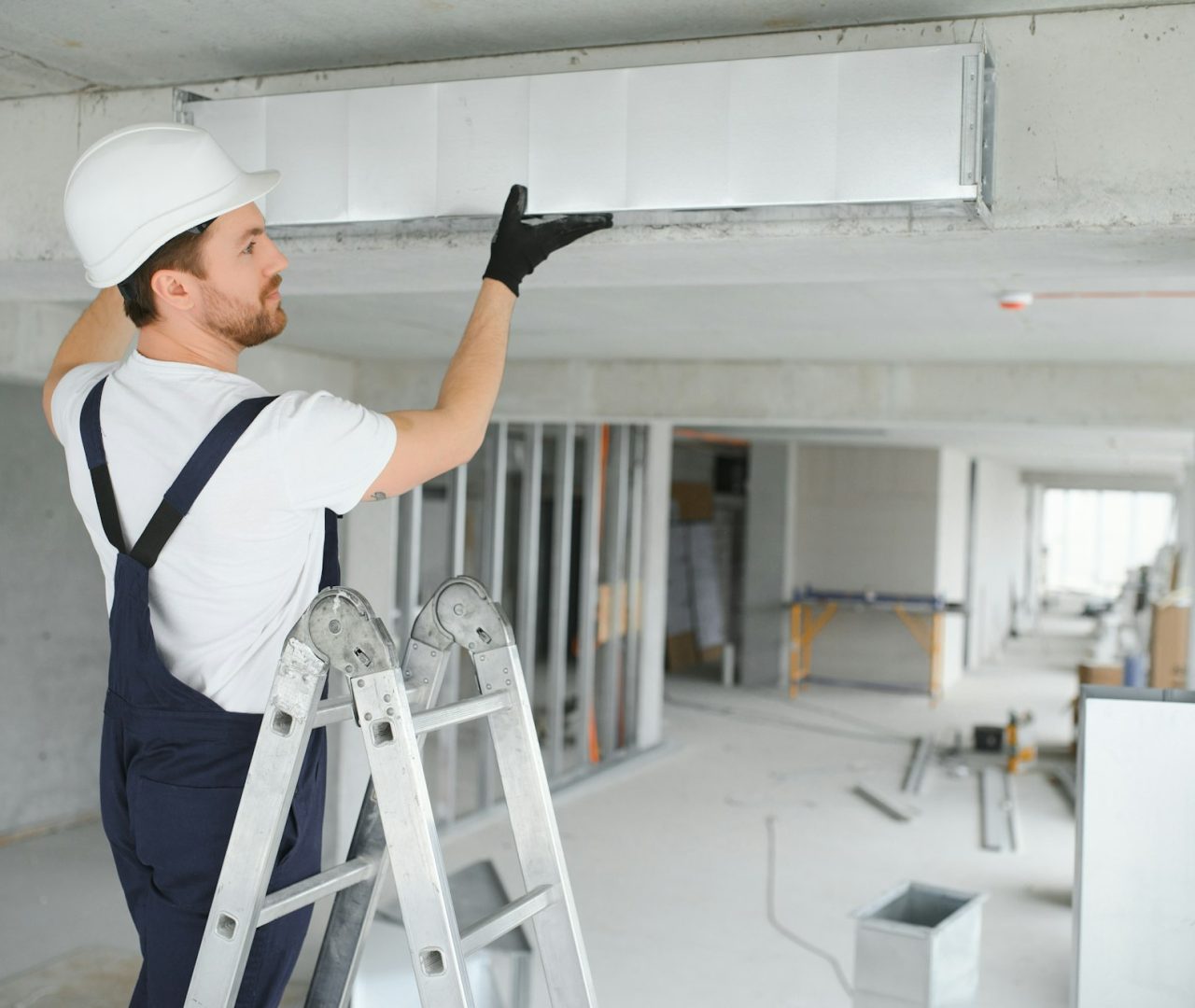 Professional HVAC Worker on a Aluminium Scaffolding Installing Air Duct